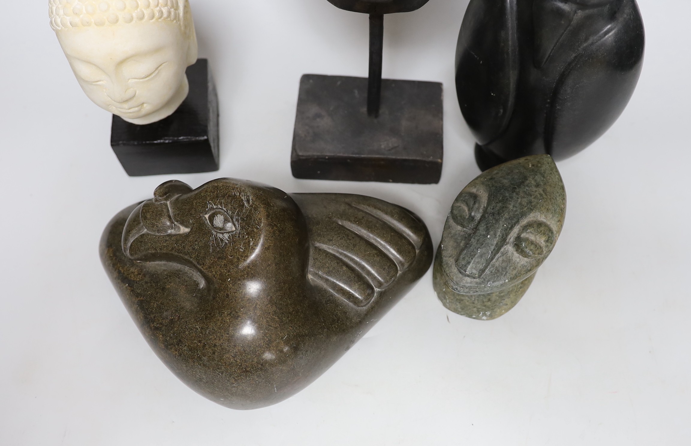 Three Inuit sculptures, a mask on stand and buddhist head, mask 39cms high